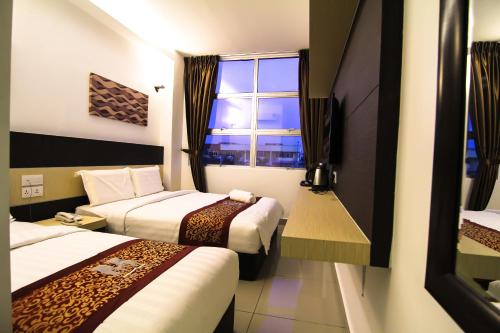 Habitación de hotel con 2 camas y ventana en Uptown Hotel Seremban, en Seremban