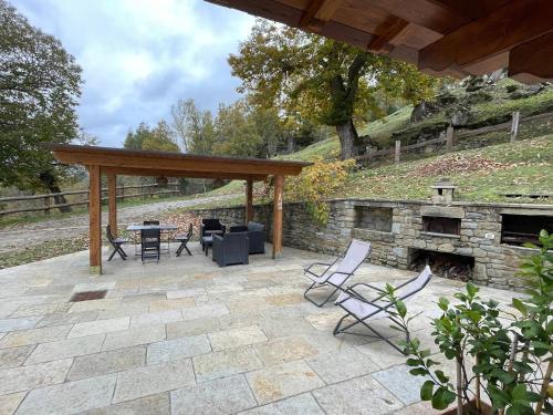 un patio con sillas y una chimenea de piedra. en Casa Palanca, en Stia
