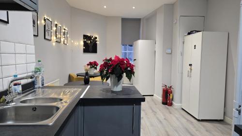 una cocina con fregadero y un jarrón de flores en un mostrador en Soho Guest House Room 5, en Londres