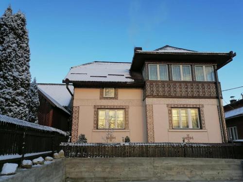a house with snow on top of it at Agrouturistic House in Manastirea Humorului in Mănăstirea Humorului