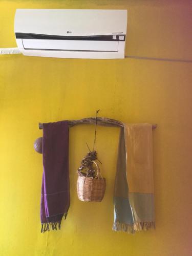 a towel rack with towels and a basket on a wall at Bunyong Homestay in Siem Reap