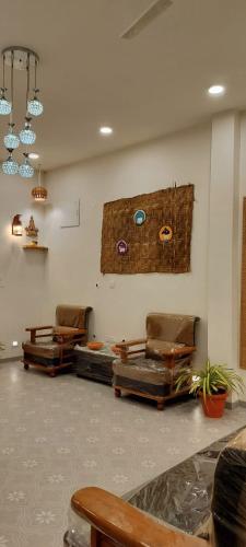 a room with two chairs and a wall with a painting at Chilkur Balaji Lakeview Villa in Gundipet