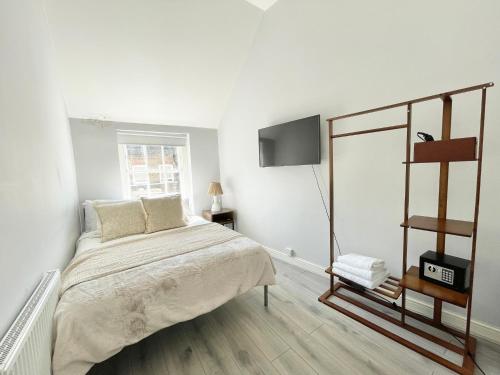 a white bedroom with a bed and a television at Soho Guest House Room 5 in London