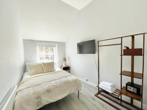 Un dormitorio blanco con una cama y un televisor. en Soho Guest House Room 5, en Londres