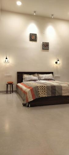 a bedroom with a bed and a table and lights at Chilkur Balaji Lakeview Villa in Gundipet