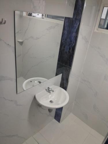 a white bathroom with a sink and a mirror at El Velero Apartamentos By DANP in Santa Marta