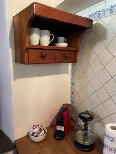 a wooden shelf with cups and dishes on a counter at Civita Home Antica Dimora in Bagnoregio