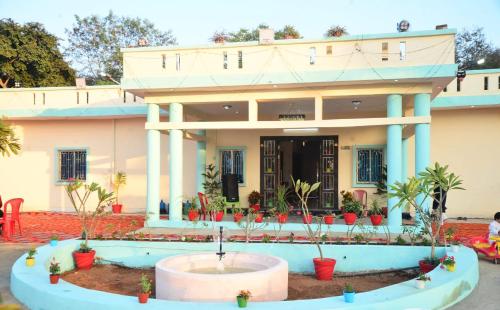 a house with a fountain in front of it at Hotel Vijay Greens in Orchha