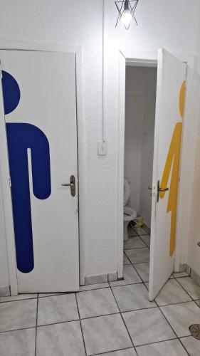 a bathroom with a door with a letter r on it at Up Hostel in Porto Alegre