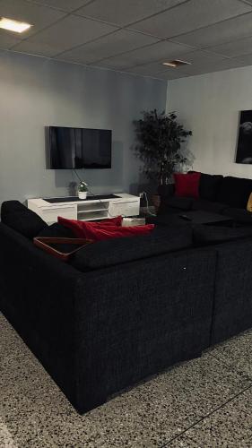 a living room with a black couch and a tv at Rentalux Apartment Rooms in Timrå