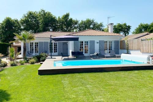 une maison avec une piscine dans une cour dans l'établissement Maison Familiale à 200 m du Bassin, à Gujan-Mestras