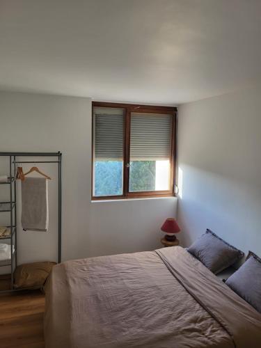une chambre avec un lit et une fenêtre dans l'établissement charment appartement au pied de trame, au Mans