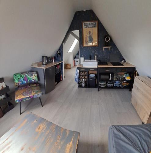 an attic room with a kitchen and a staircase at Le grenier de Mamou in Hesdigneul-lès-Boulogne