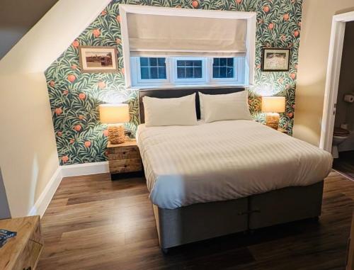 a bedroom with a large bed with a window at The FightingCocks in Fordingbridge