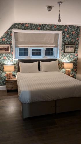 a bedroom with a large bed with a window at The FightingCocks in Fordingbridge