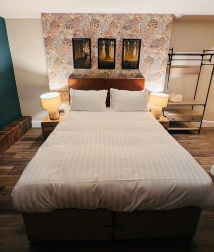 a bedroom with a large bed with two lamps on it at The FightingCocks in Fordingbridge
