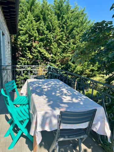 une table et deux chaises assises sur un balcon dans l'établissement Villa La Baronnie - 11 pers - Proche Brive -Jardin, à Ussac