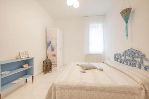 a white bedroom with a blue and white bed at Venice Marine - 10 minuti da Venezia in Mestre