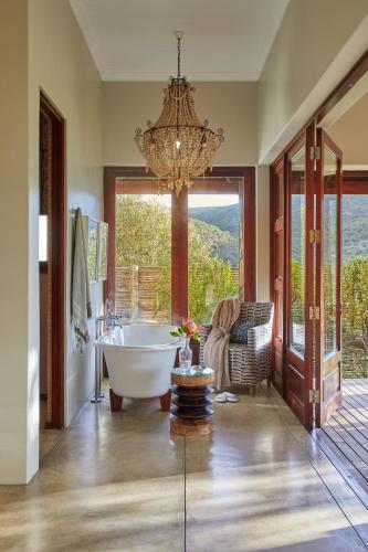 a bathroom with a tub and a chandelier at Kwandwe Private Game Reserve - Melton Manor in Grahamstown