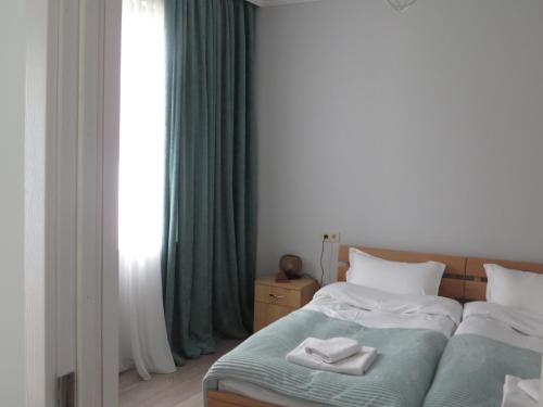 a bedroom with a bed with two towels on it at Guesthouse Bacha & Lia in Mestia