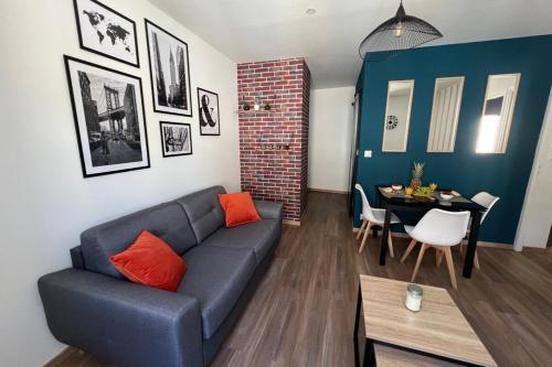 un salon avec un canapé bleu et une table dans l'établissement Casa Faro -T2 -Hyper Centre Brive -Rue Commerçante, à Brive-la-Gaillarde