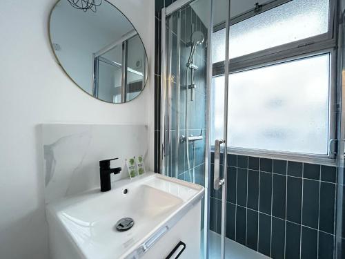 une salle de bain avec un lavabo et un miroir dans l'établissement Le Théâtre studio cosy en coeur de ville, à Limoges