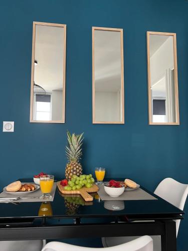 une table avec des fruits et des légumes sur un mur bleu dans l'établissement Casa Faro -T2 -Hyper Centre Brive -Rue Commerçante, à Brive-la-Gaillarde