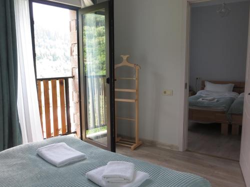 a bedroom with a bed with two towels on it at Guesthouse Bacha & Lia in Mestia