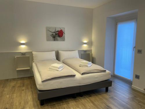 a bed in a room with two towels on it at Cà Marasciol in Villa di Tirano