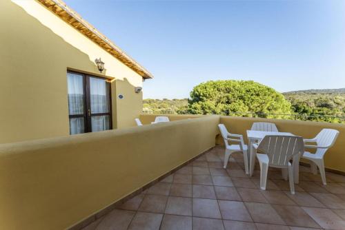 a balcony with white chairs and tables on it at Il Mirto Appartamenti, Ac e Wifi, Gallura in Vignola Mare