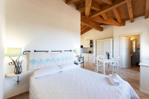 a bedroom with a large white bed and a table at Il Mirto Appartamenti, Ac e Wifi, Gallura in Vignola Mare