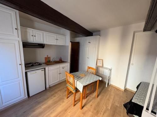 une petite cuisine avec une table et une table et des chaises dans l'établissement Studio Cosy hyper centre Aix, à Aix-en-Provence