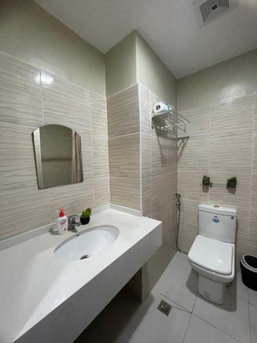 a white bathroom with a sink and a toilet at Bamboo Bay Community condominium in Mandaue City