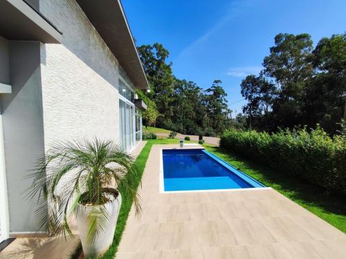 ein Haus mit einem Swimmingpool und einer Palme daneben in der Unterkunft Casa de Campo Ninho Verde Eco Residence in Quadra