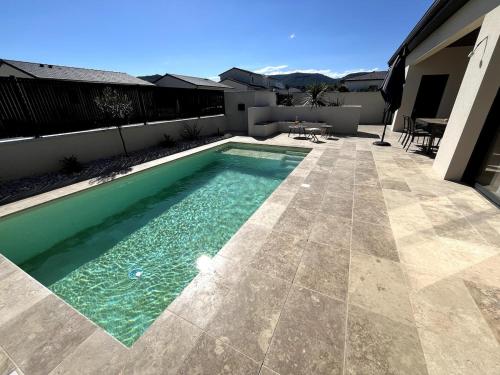 a swimming pool on a patio with a house at Villa exotique avec piscine - Dolce Rhôna in Charmes-sur-Rhône