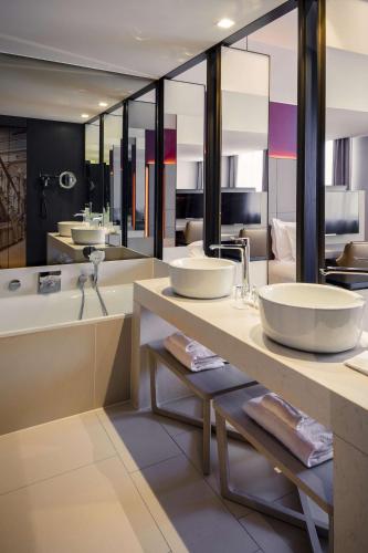 a bathroom with two sinks and a bath tub and a tub at Anantara Grand Hotel Krasnapolsky Amsterdam in Amsterdam