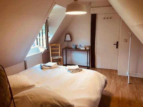 a bedroom with a large white bed in a attic at Maison rénovée - jacuzzi et cheminée in Saint-Samson-de-la-Roque