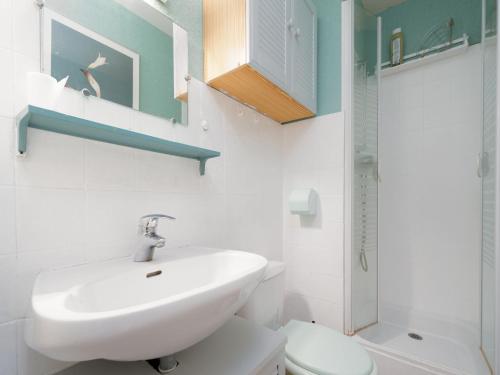 une salle de bain blanche avec un lavabo et des toilettes dans l'établissement Citadelle du Soleil N 164 - ST4, au Grau-du-Roi