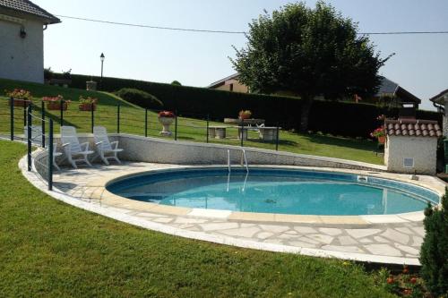 une piscine dans une cour avec des chaises autour dans l'établissement Villa Pougeol - 6 pers - PiscineBarbecuePétanque, à Chanac-les-Mines