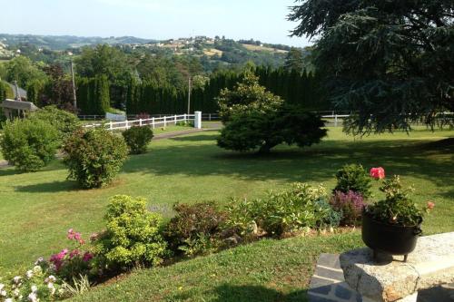 d'un jardin avec des fleurs et une clôture blanche. dans l'établissement Villa Pougeol - 6 pers - PiscineBarbecuePétanque, à Chanac-les-Mines