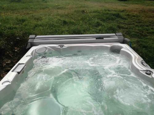 a jacuzzi tub with water in a yard at Maison rénovée - jacuzzi et cheminée in Saint-Samson-de-la-Roque