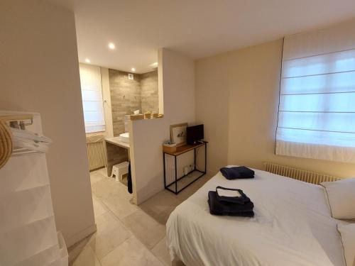 a bedroom with a bed with a bag on it at Maison rénovée - jacuzzi et cheminée in Saint-Samson-de-la-Roque