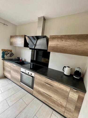 - une cuisine avec un comptoir noir et une cuisinière dans l'établissement Casa Viallatoux - Proche Centre - Parking Gratuit, à Brive-la-Gaillarde