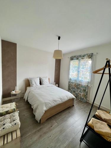 une chambre blanche avec un grand lit et une fenêtre dans l'établissement Casa Viallatoux - Proche Centre - Parking Gratuit, à Brive-la-Gaillarde