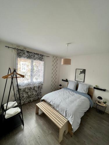 une chambre avec un lit et un banc dans l'établissement Casa Viallatoux - Proche Centre - Parking Gratuit, à Brive-la-Gaillarde