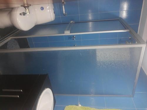 a blue tiled bathroom with a toilet and a sink at Cálida Casa Zil&Li coliving Tunja in Tunja