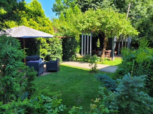 a garden with a lawn and an umbrella at Willa Nad Potokiem in Kudowa-Zdrój