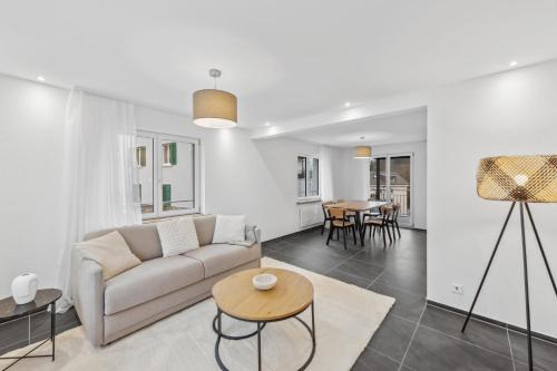 a living room with a couch and a table at The R Apartment Rheinfall - central free parking in Neuhausen am Rheinfall