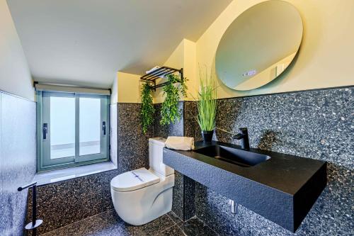 a bathroom with a sink and a toilet and a mirror at SUNSET MALAGA - PRIME & DESIGN in Málaga