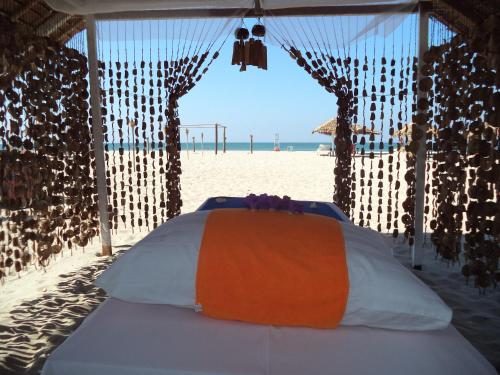 a bed in a tent on the beach at Eskala Hotels and Resorts in Ngwesaung
